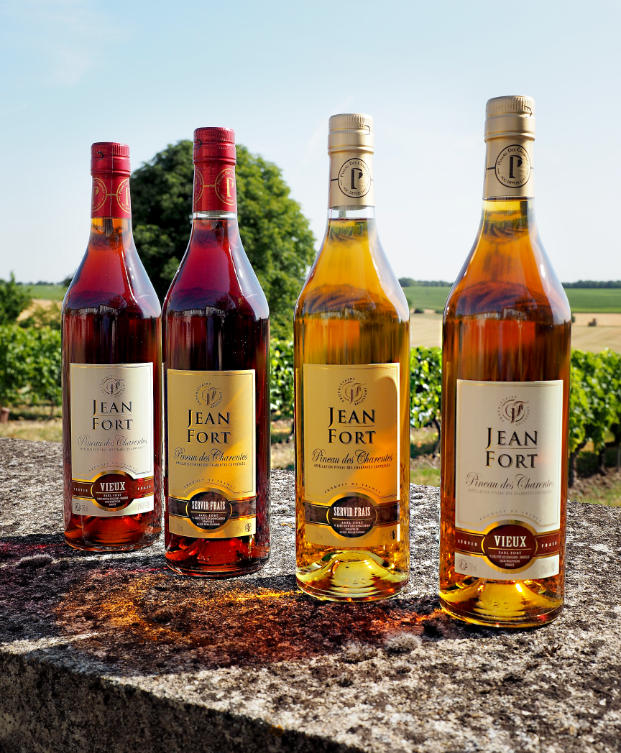 Bouteilles de Pineau des Charentes blanc et rosé du producteur Jean Fort, avec des verres de dégustation.