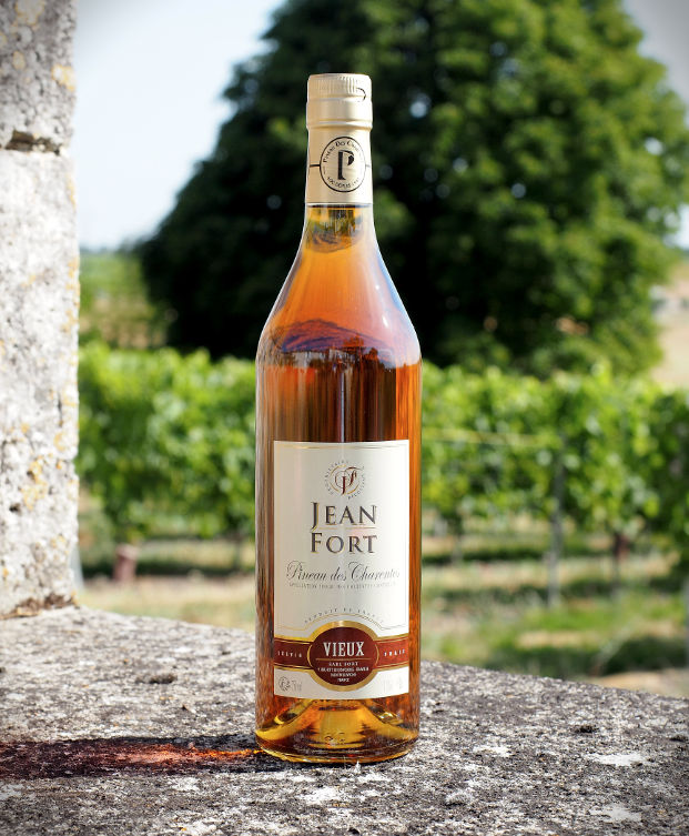Bouteilles de Pineau des Charentes blanc et rosé du producteur Jean Fort, avec des verres de dégustation.