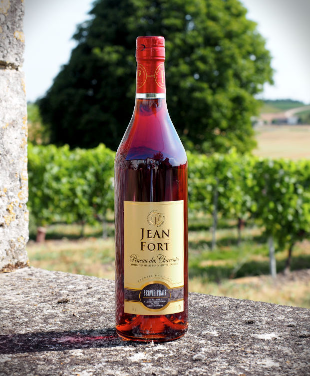 Bouteilles de Pineau des Charentes blanc et rosé du producteur Jean Fort, avec des verres de dégustation.